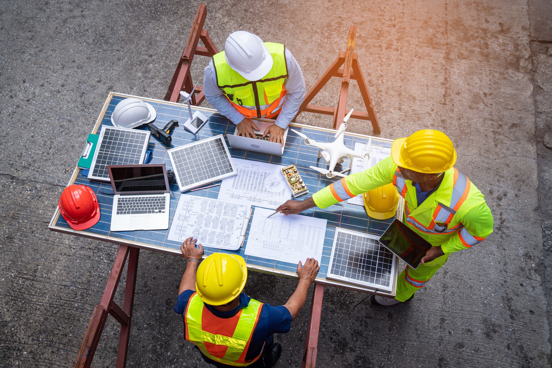 Top view of team engineer working on solar panel and his blueprints with Solar photovoltaic equipment on construction site.